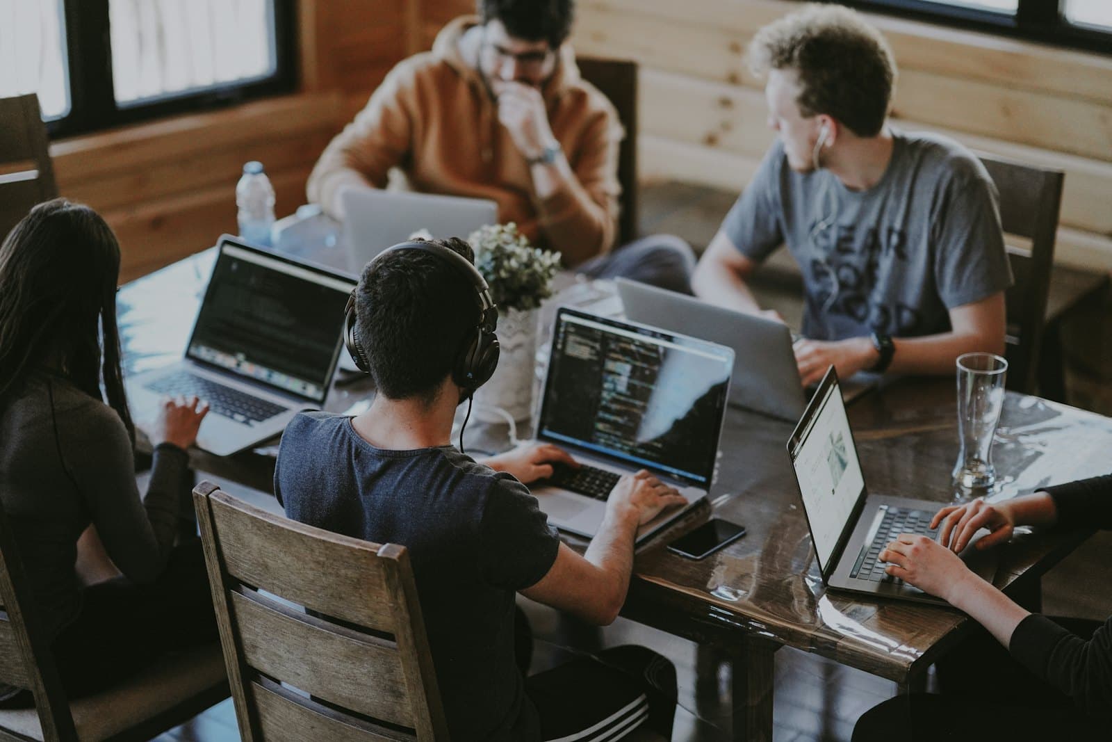 Travel consultants planning an itinerary at a table of laptops